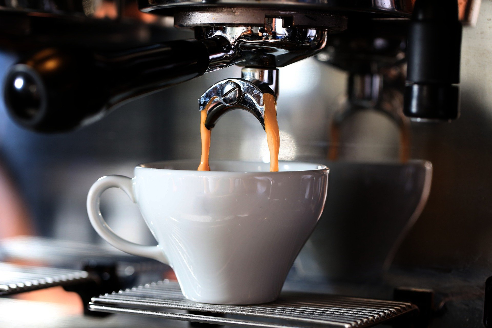 A coffee mug below an espresso machine