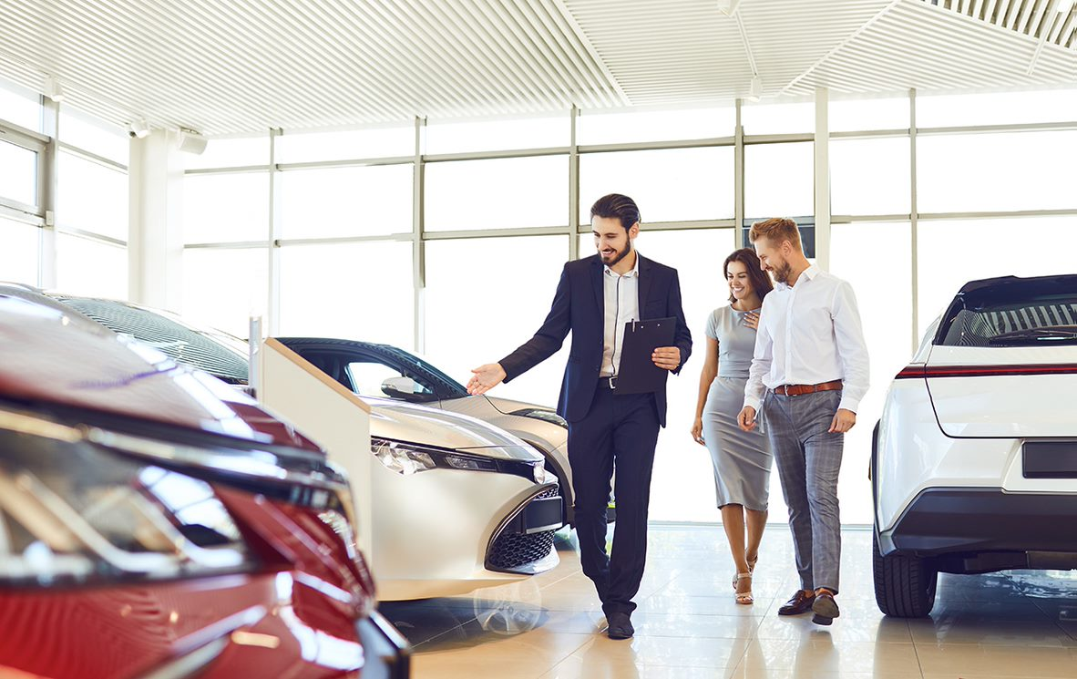 Salesman showing couple a car